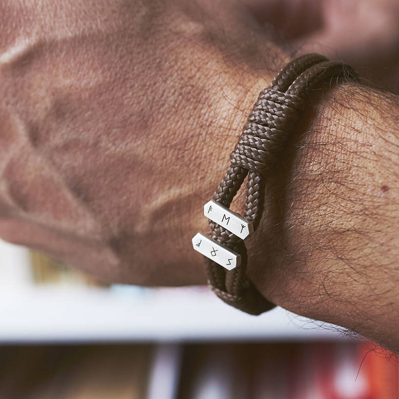 men's personalised sterling silver brown cord bracelet personalised with an ancient symbols on men's wrist by Sally Clay Jewellery