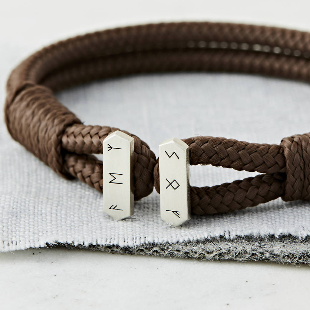 close up of men's personalised sterling silver brown cord bracelet personalised with an ancient symbols by Sally Clay Jewellery