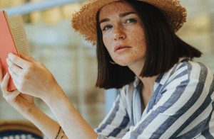 Woman in straw hat reading a book
