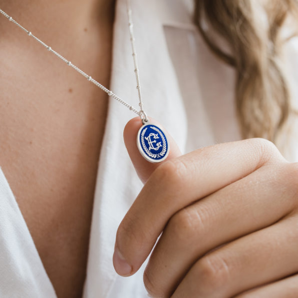 silver pendant necklace with entwined monogram and blue enamel